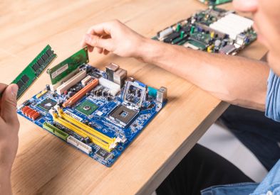 Professional electronic repair technician diagnosing laptop motherboard in Al Barsha Dubai