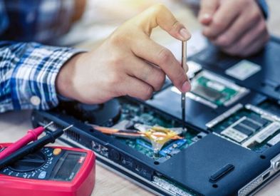 Professional technician diagnosing a laptop for customers in JBR Dubai